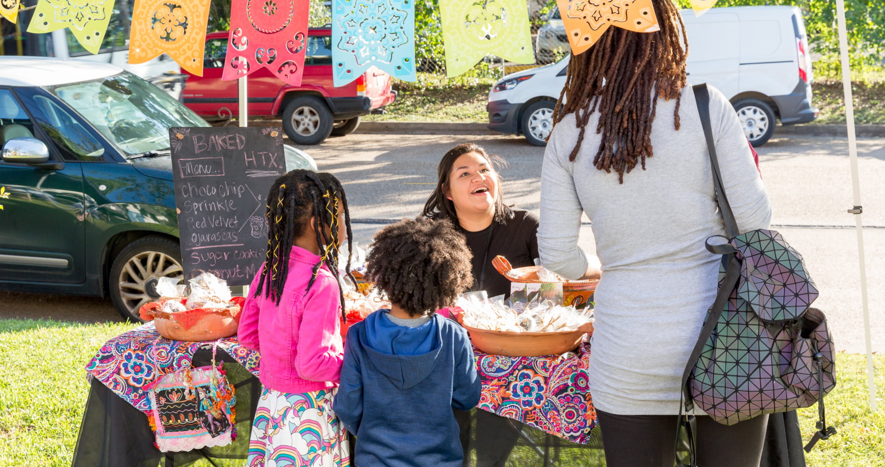 Family buying baked goods from street vendor